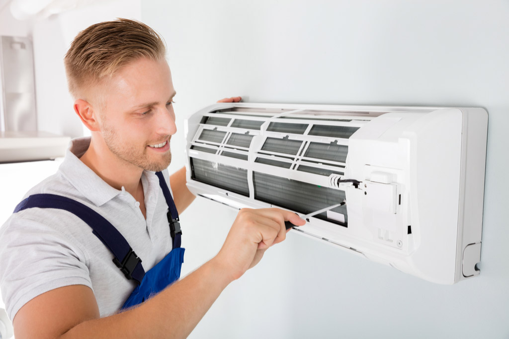 HVAC technician cleaning and repairing a ductless mini split AC in Queen Creek, AZ