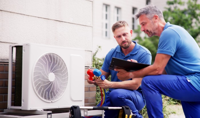 HVAC technicians reviewing an outdoor air conditioning unit in Queen Creek, AZ
