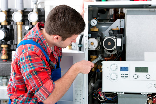 HVAC technician inspecting an indoor heating system in Queen Creek, AZ