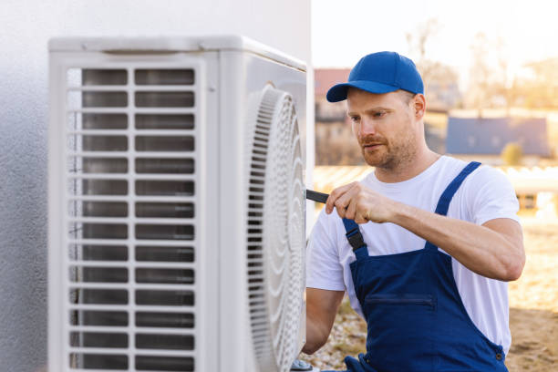 HVAC technician servicing an outdoor air conditioning unit in Queen Creek