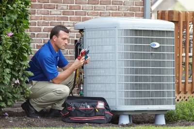 HVAC technician inspecting an outdoor air conditioning unit in Queen Creek, AZ